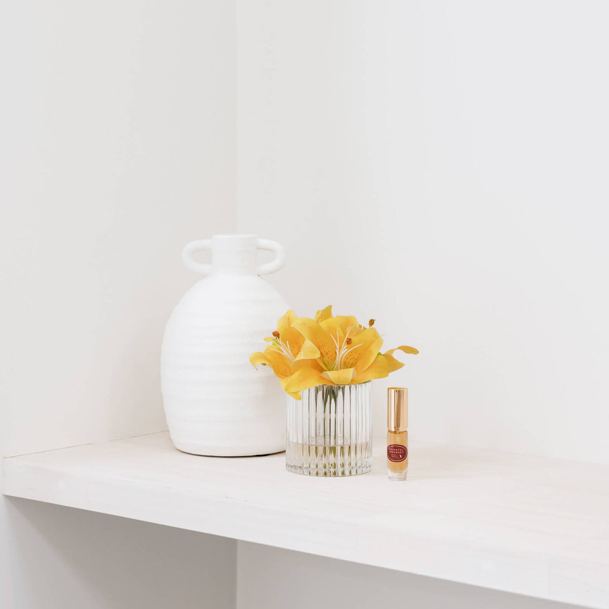 Silk yellow lily flowers in vase with perfume