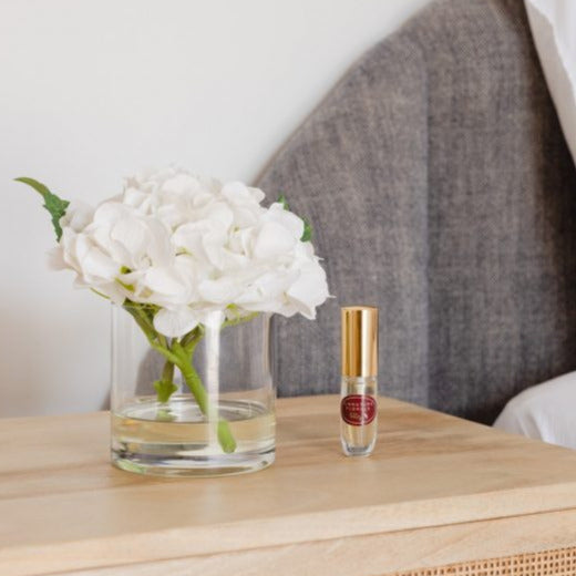 An artificial white hydrangea flower arrangement paired with a floral scent spray